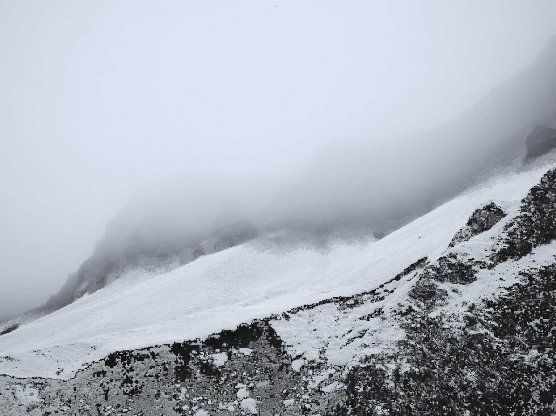 Ein verschneiter Grat, der im Nebel verschwindet