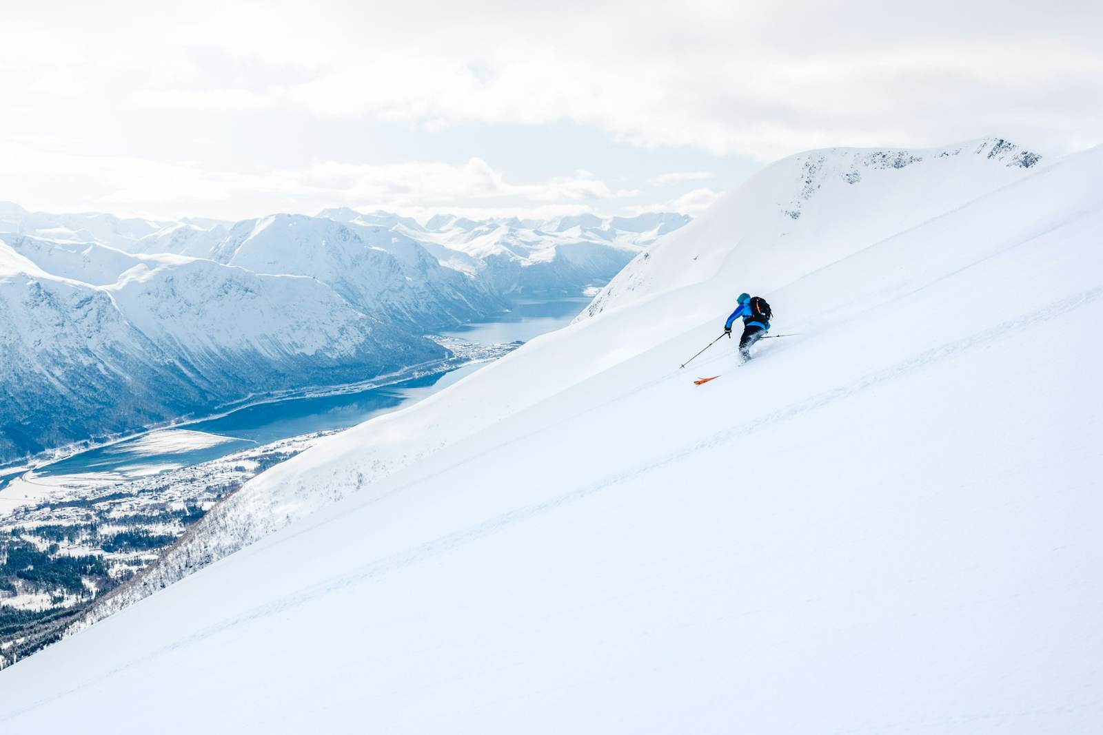 Skifahrer an steilem Hang über dem Tal